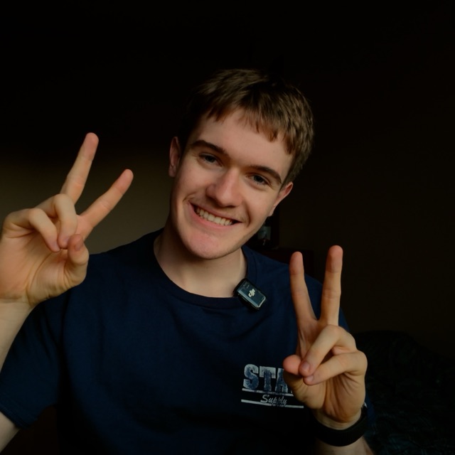 Patrick, smiling with two peace signs